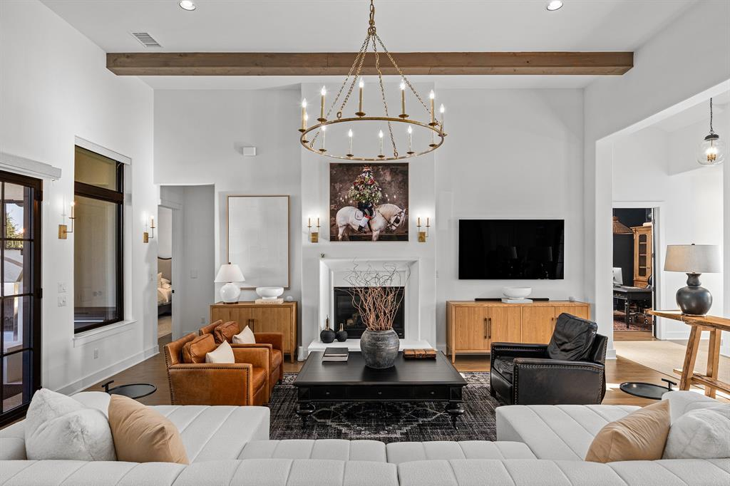 Living room wide view — dual sofas, fireplace and beamed ceilings