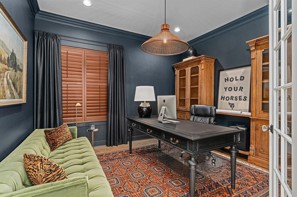 Home office with navy walls, pendant light, executive desk and French doors