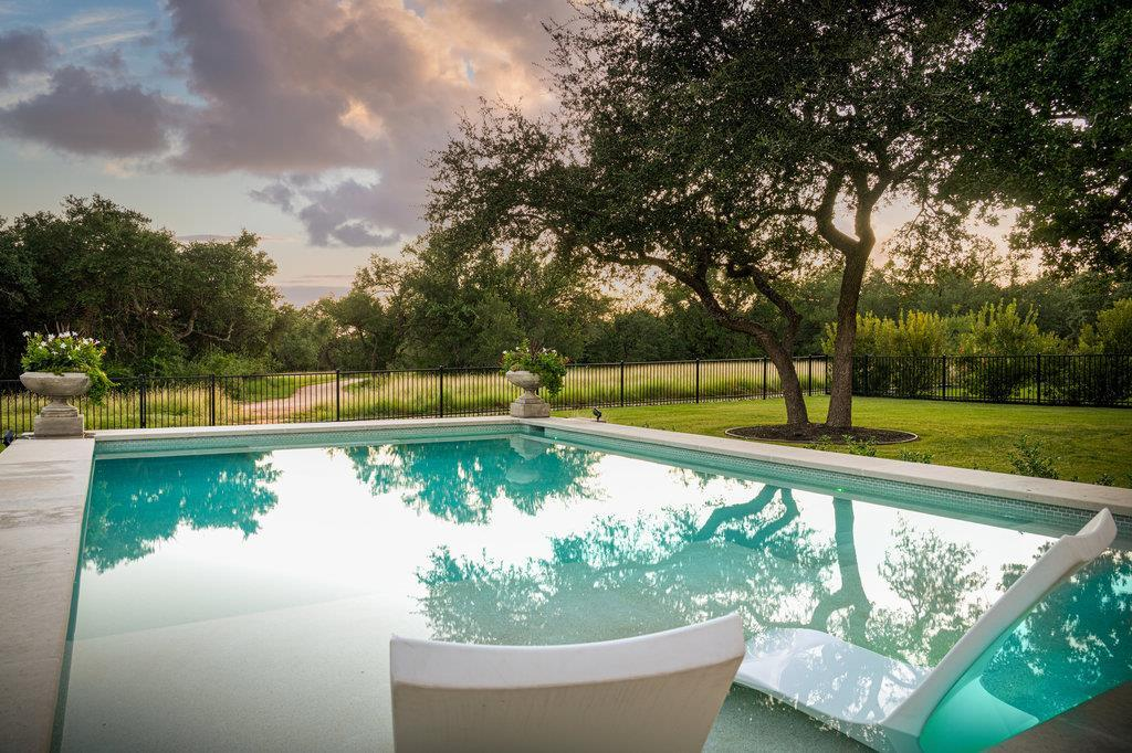 Pool at sunset with in-water lounger and mature oak trees